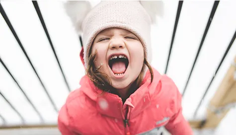 Child in red coat enjoying life