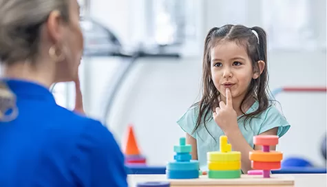 Woman works with girl, CDI staff doing Speech and language therapy